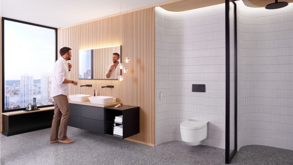 Mann in Badezimmer vor Spiegel Geberit Option Plus Square und schwarzen Geberit ONE Badmöbeln (© Geberit) Mann in Badezimmer vor Spiegel Geberit Option Plus Square und schwarzen Geberit ONE Badmöbeln (© Geberit)